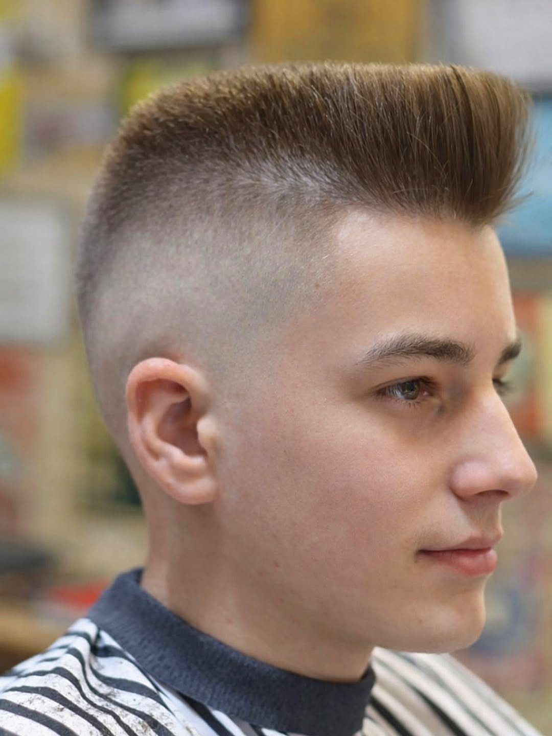 Young man with a pompadour haircut featuring high volume on top and faded sides.