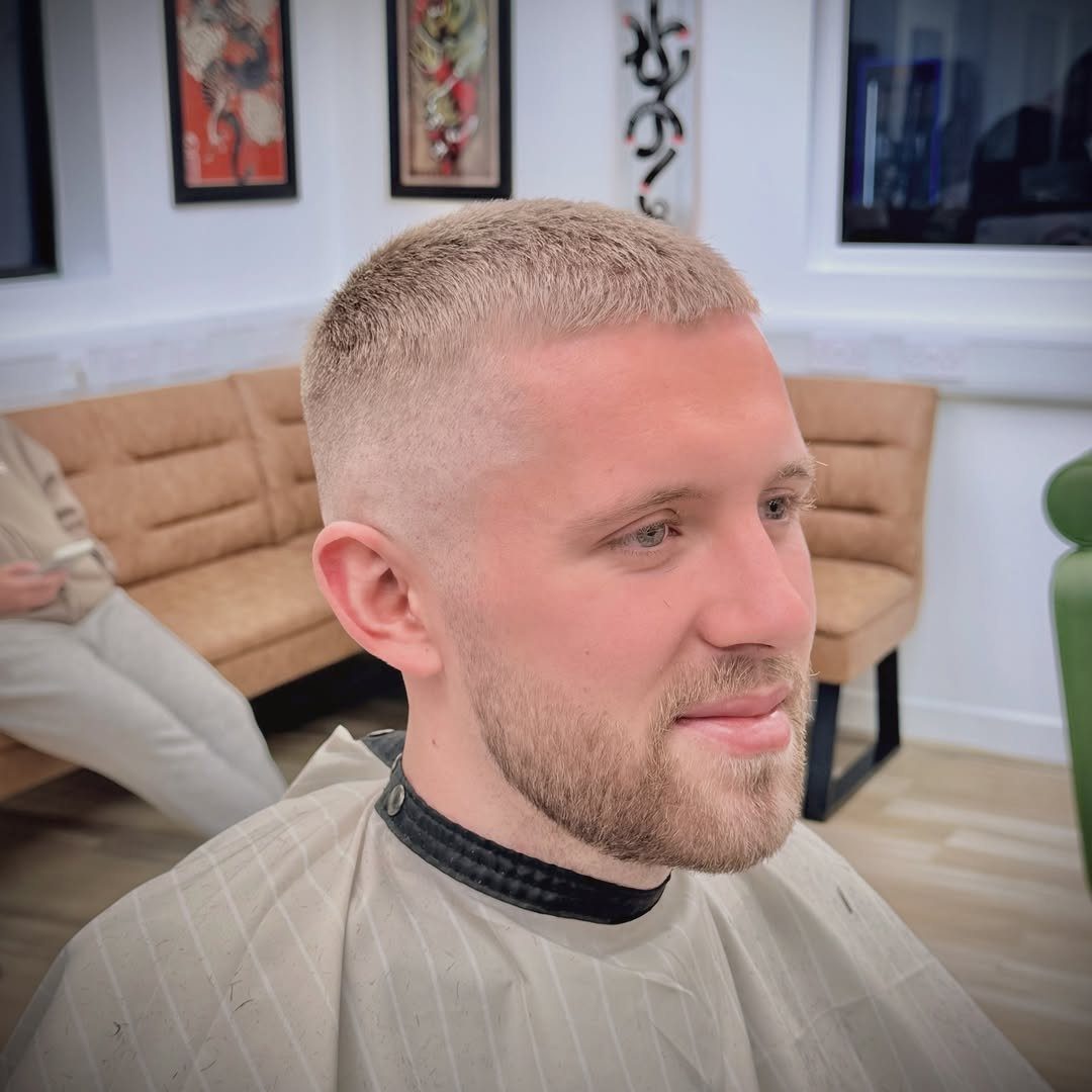 Man with a short buzz cut hairstyle and beard in a barber shop