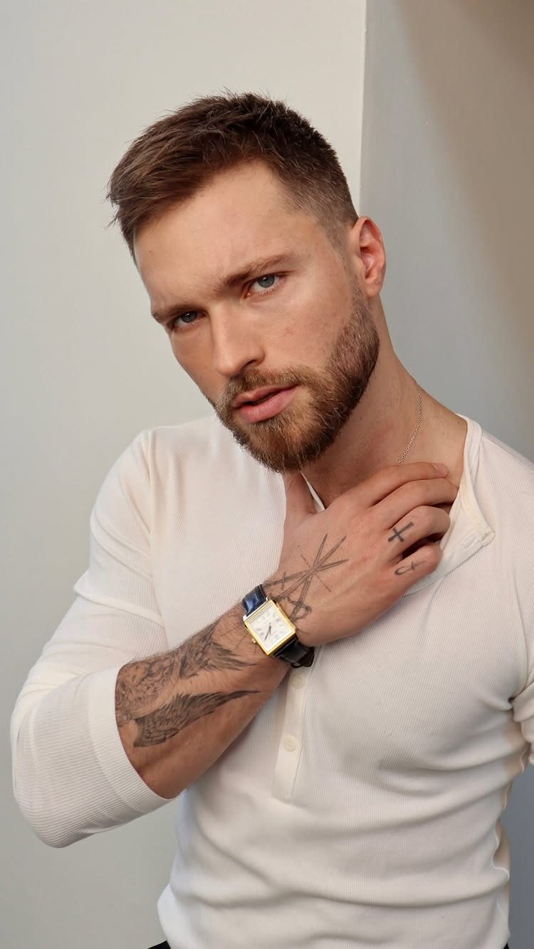 Man with a crew cut fade hairstyle and a groomed brown beard.