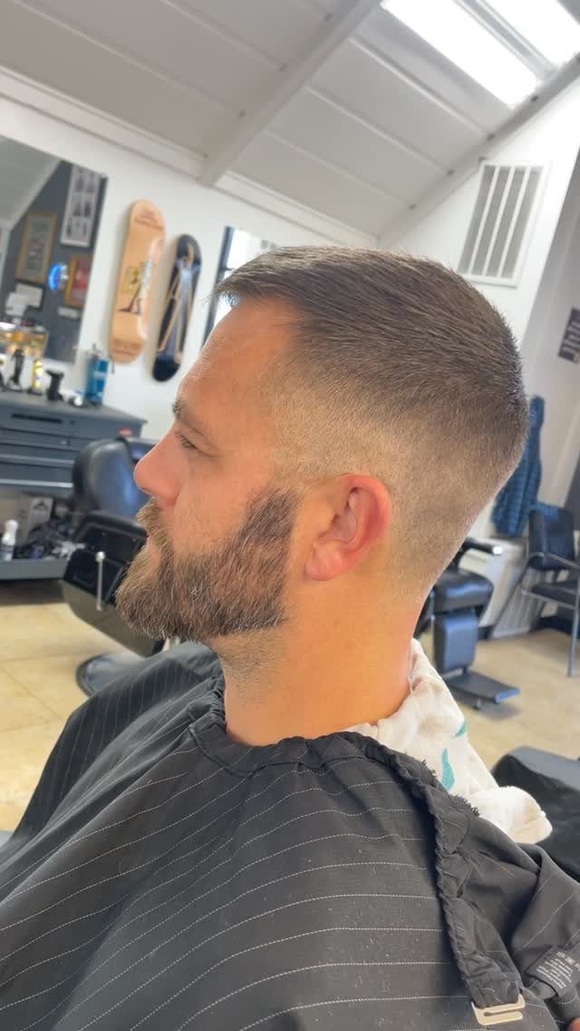 Man with a short crew cut and fade in a barbershop setting.
