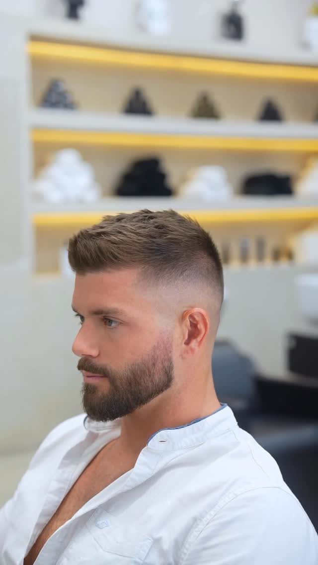Man with a short fade haircut and groomed beard in a barbershop