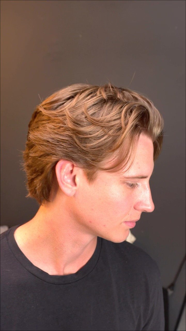 Young man with medium-length light brown hair swept back in a natural bro flow.