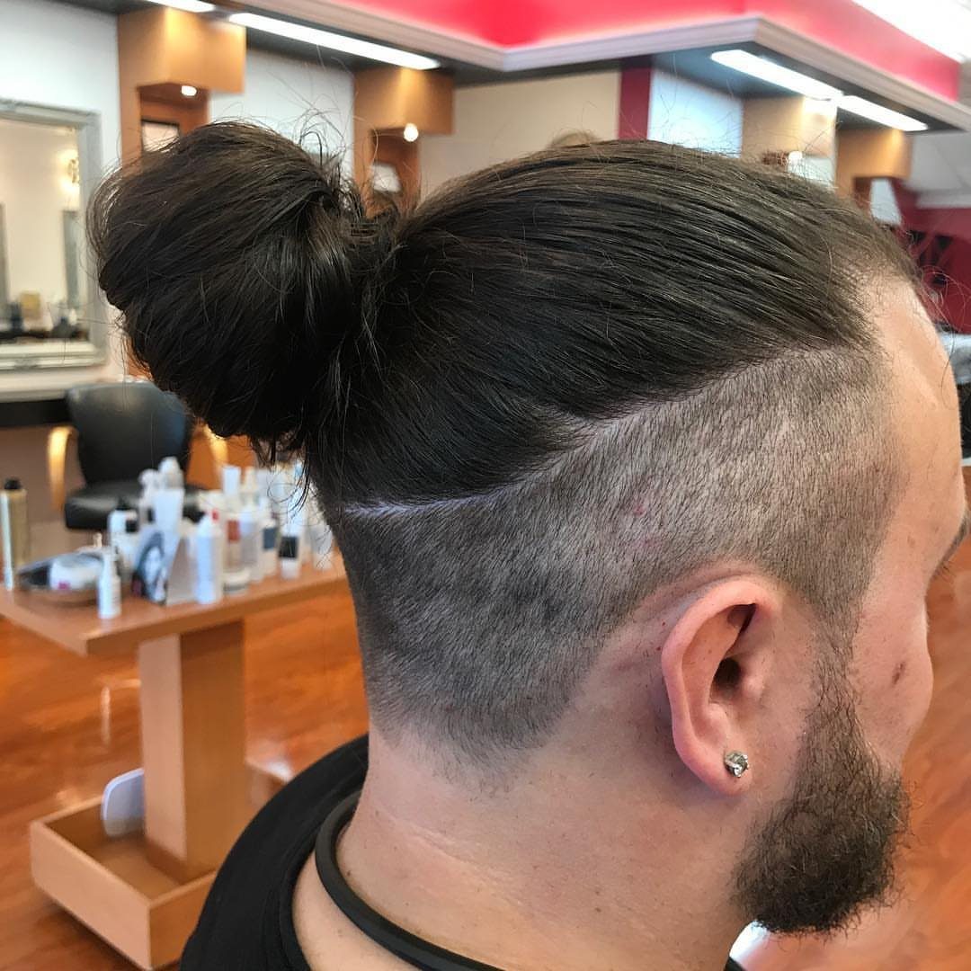 Man with a dark brown man bun and shaved undercut in a salon