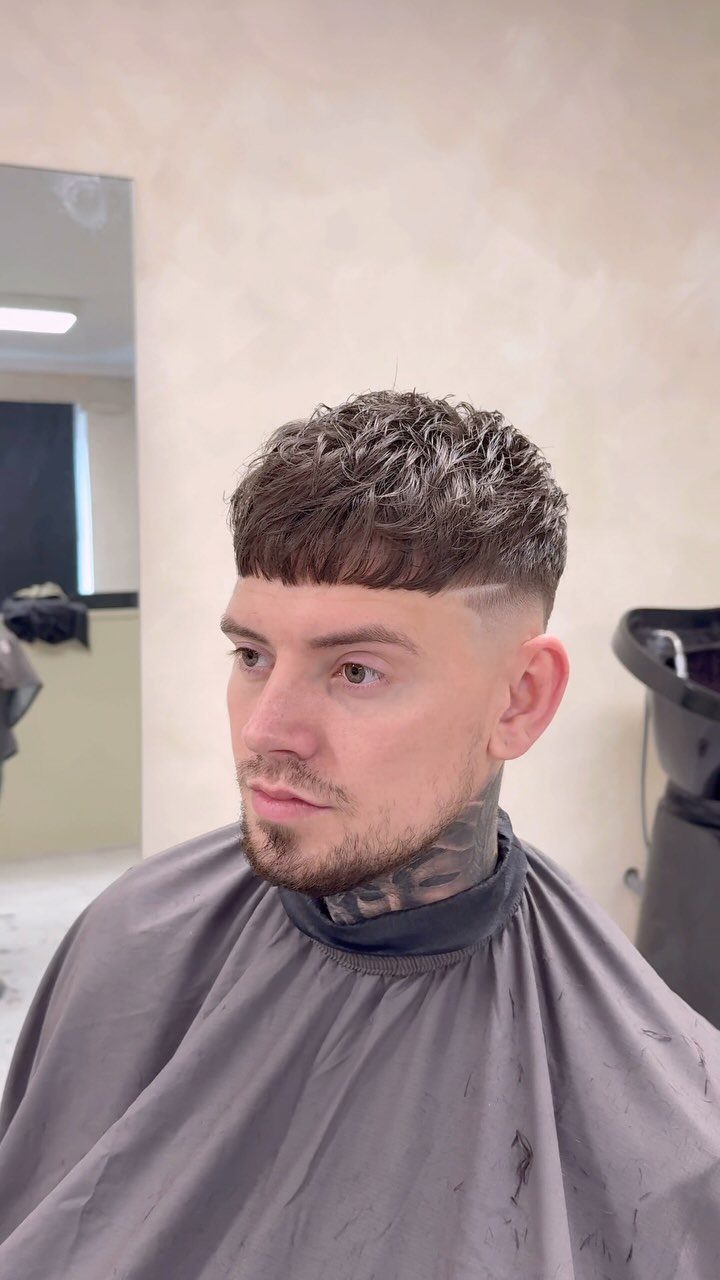 Man with a textured medium crop haircut and faded sides in a barbershop