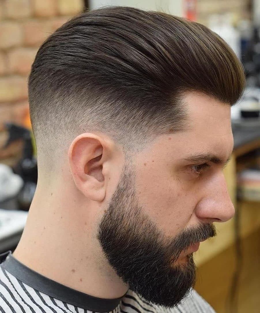 Man with a slicked-back medium haircut, faded sides, and a full groomed beard.