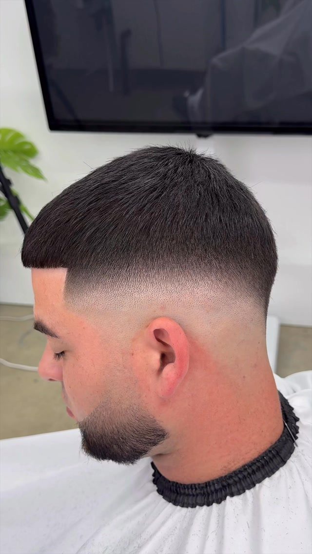 Man with a buzz cut and skin fade haircut and groomed beard.