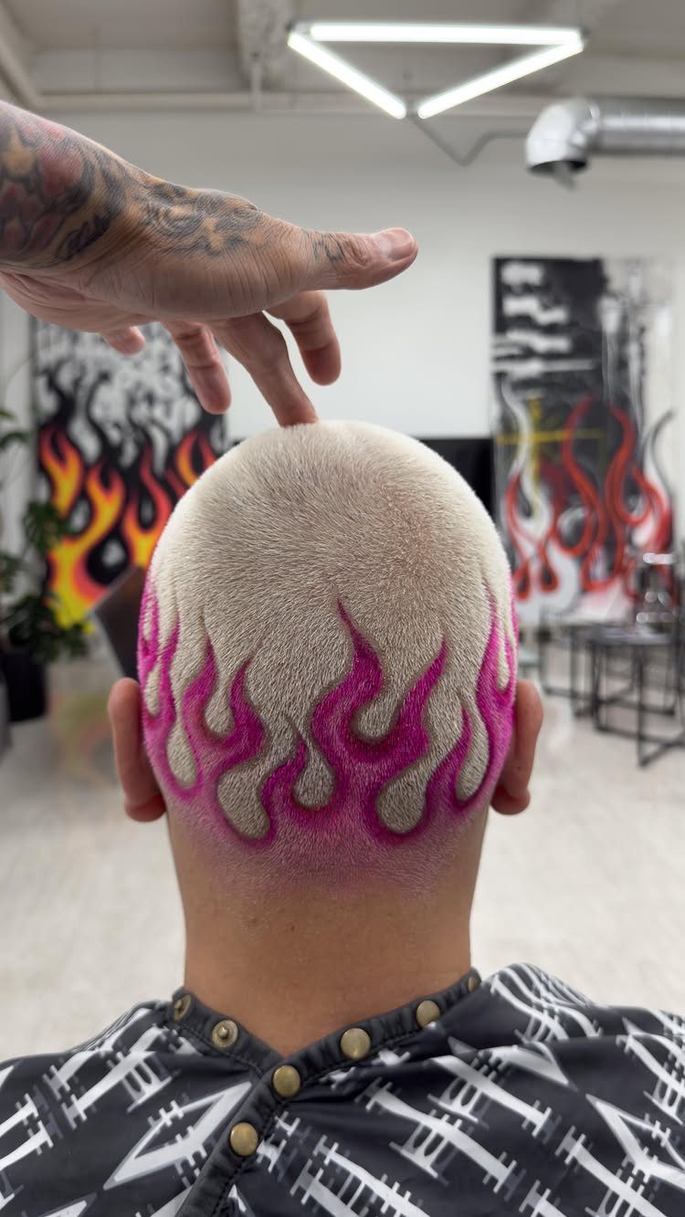 Man with a blonde buzz cut and pink flame shaved design on back