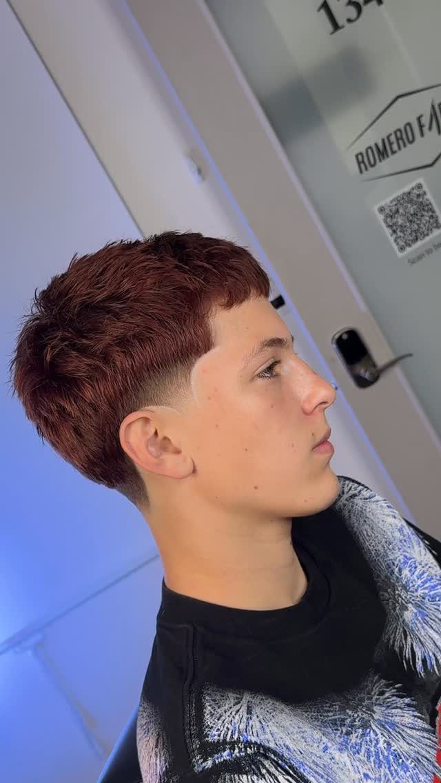 Young man with a reddish-brown short haircut and a high skin fade.