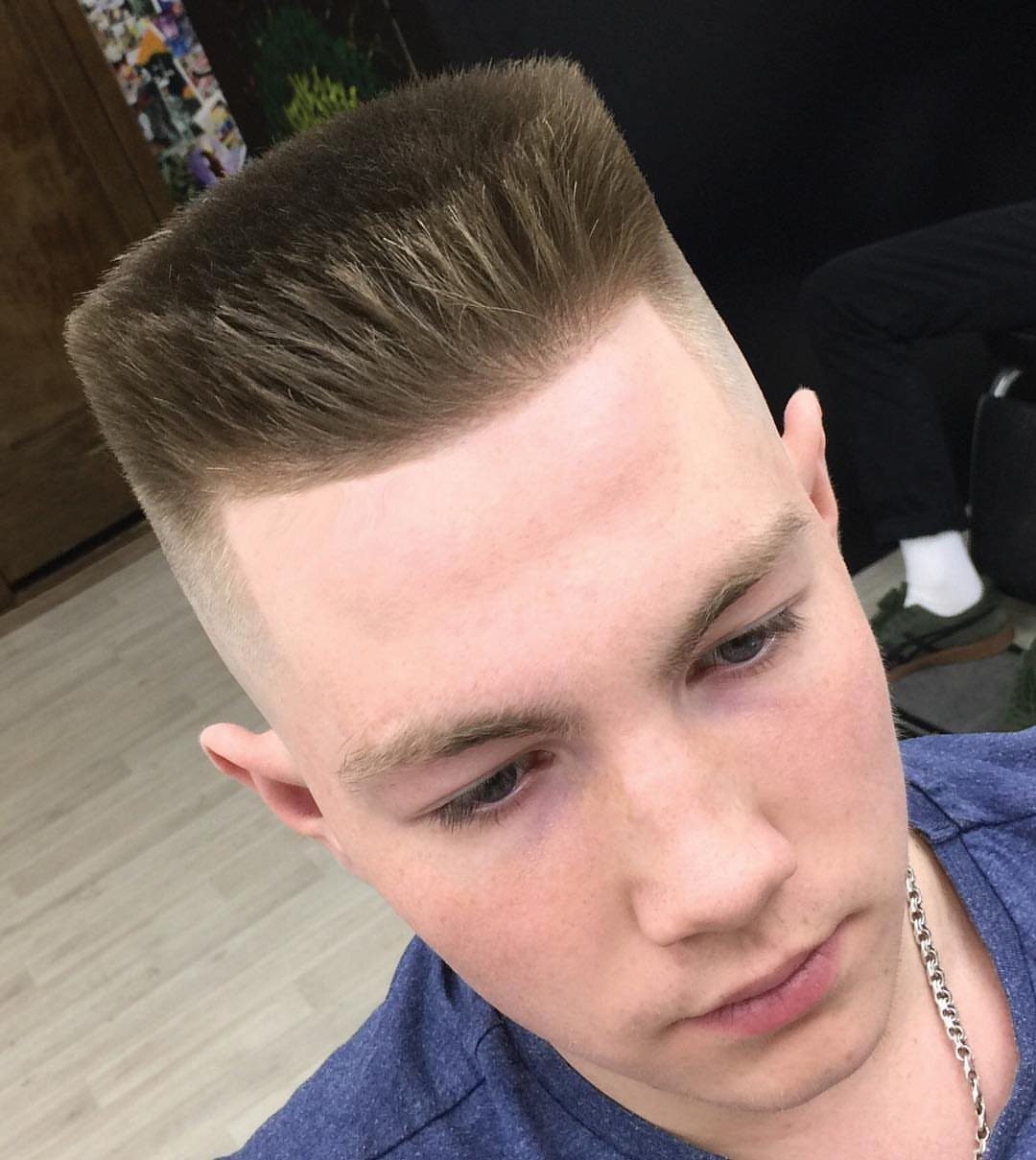 Young man with a precise flat top haircut and faded sides.