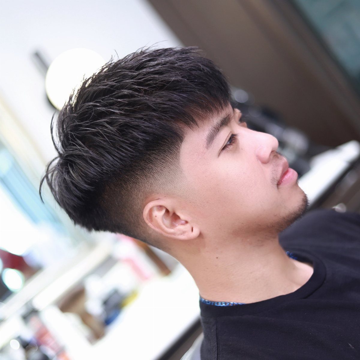Man with a French crop haircut featuring faded sides and textured top fringe.