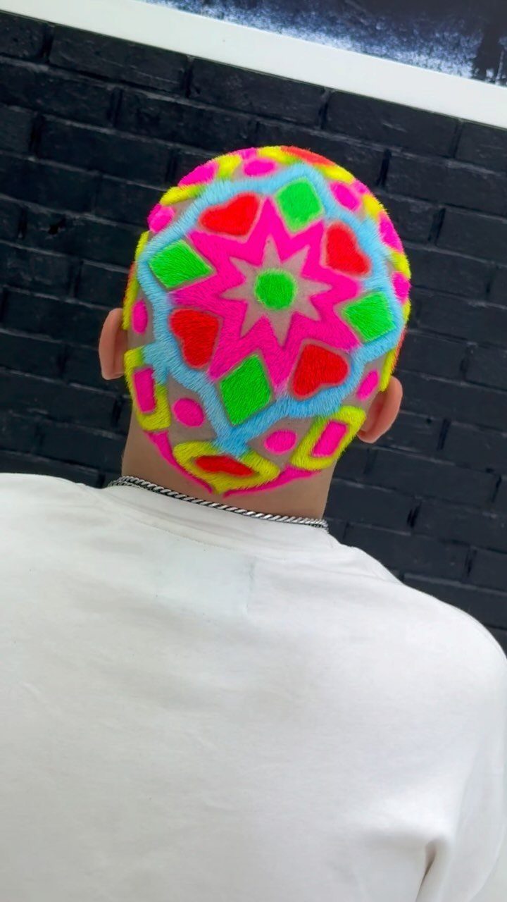Man with a buzz cut featuring a colorful neon geometric hair dye pattern.