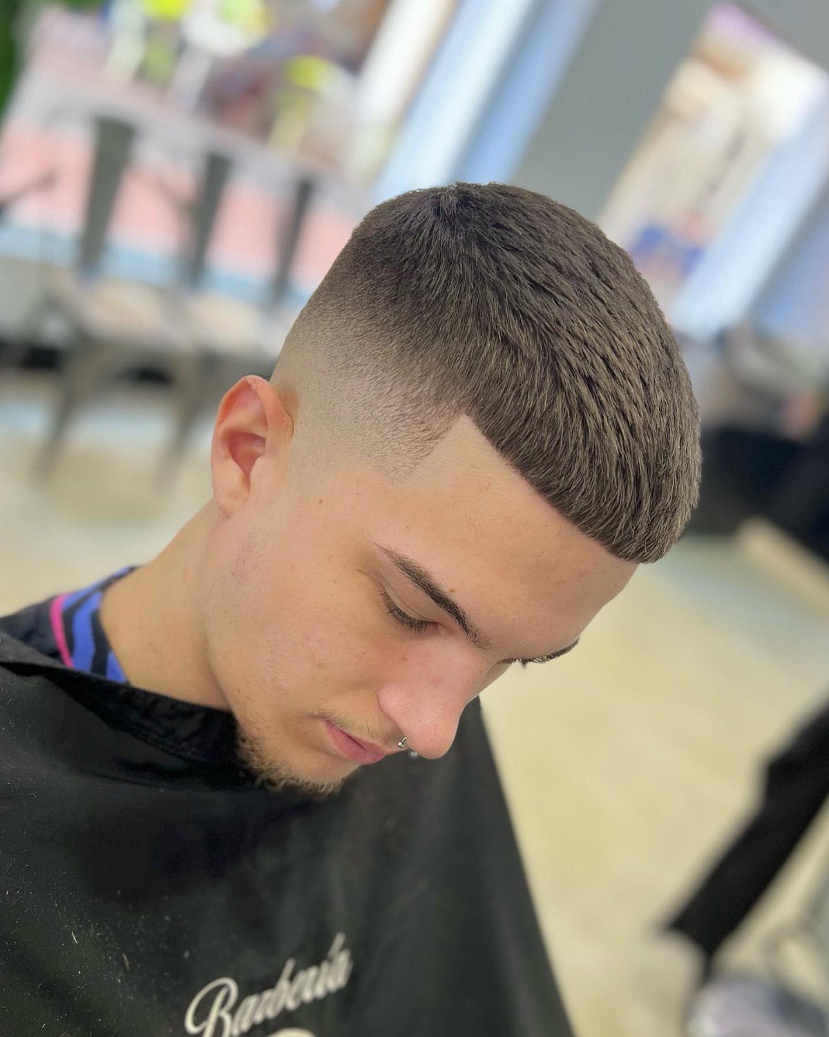 Young man with a short crop haircut, blunt fringe, and high skin fade.