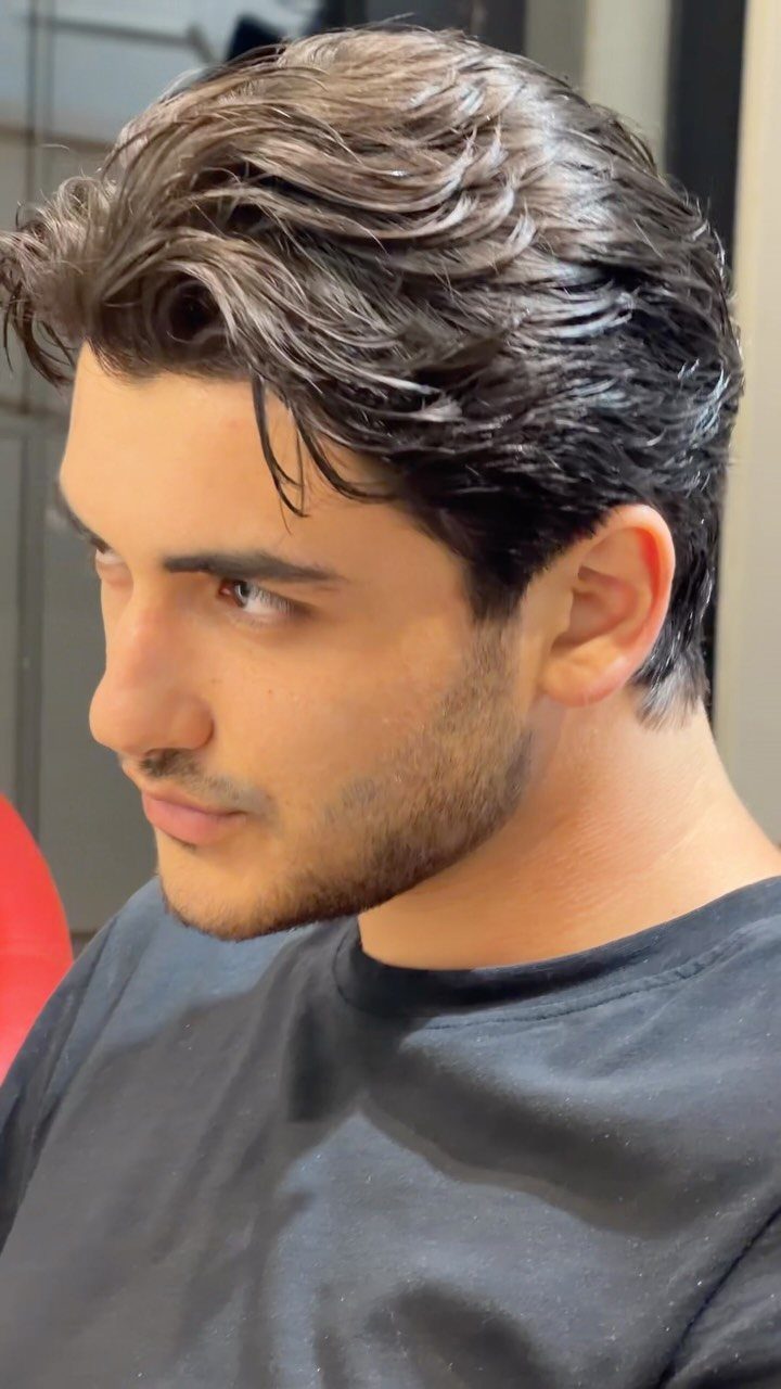Young man with a short, styled dark brown haircut and groomed beard.