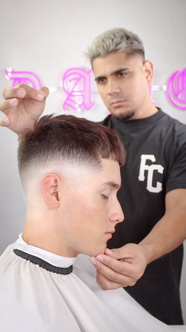 Man with a skin fade haircut being styled by a professional barber.