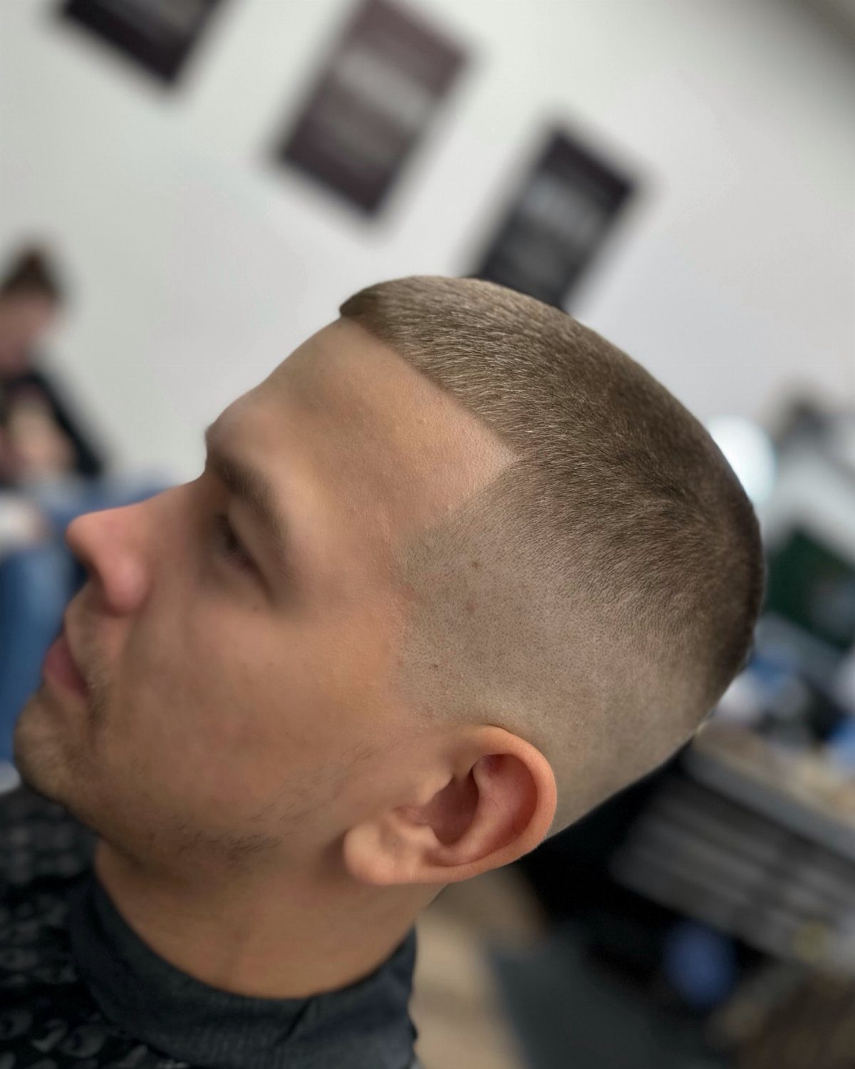 Man with a short buzz cut and high skin fade in a barbershop