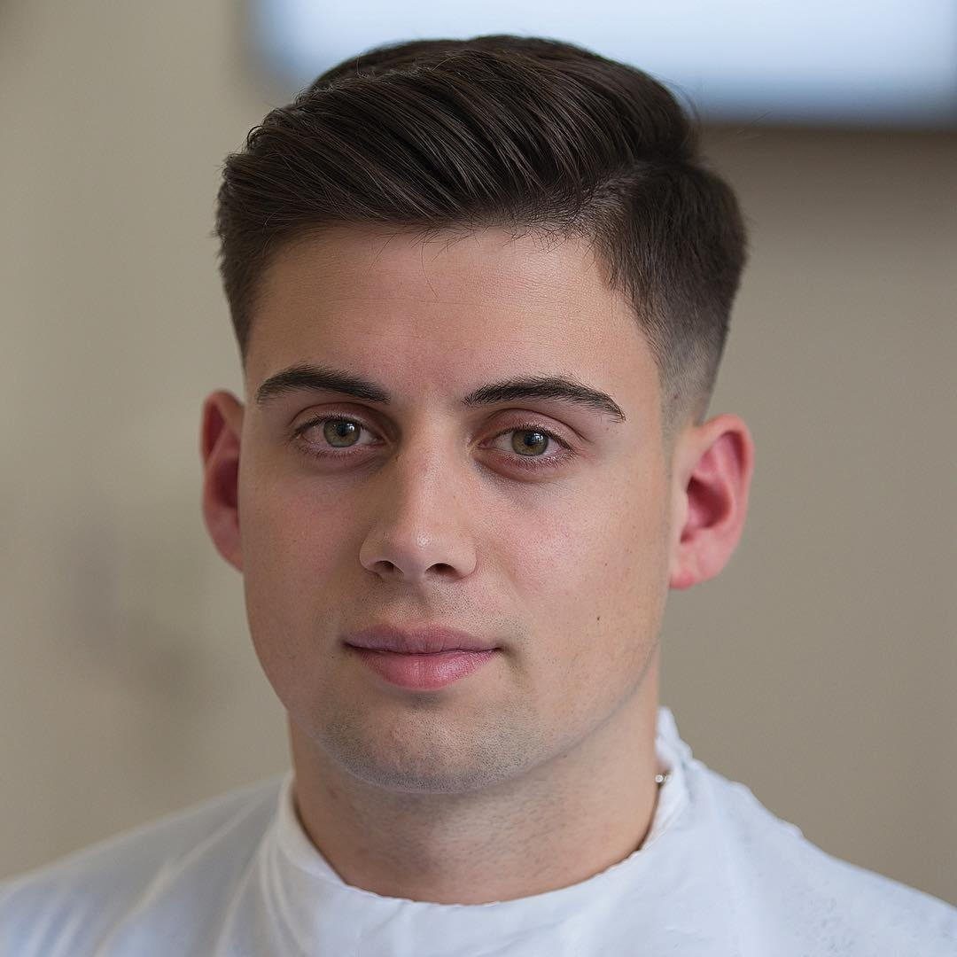 Young man with a neat Ivy League haircut and faded sides.