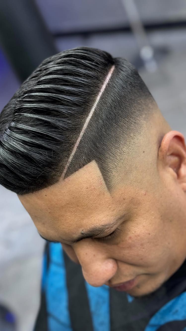 Man with a side-parted comb over hairstyle and a high skin fade.
