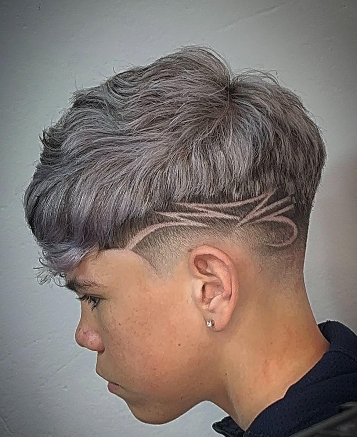 Young man with silver hair and a shaved artistic pattern on the side.