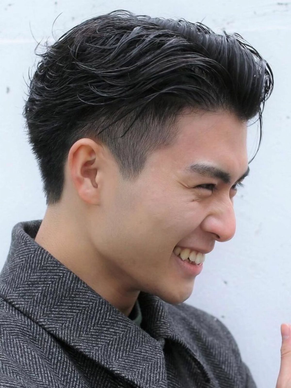 Man with an undercut hairstyle, long dark hair on top and shaved sides.