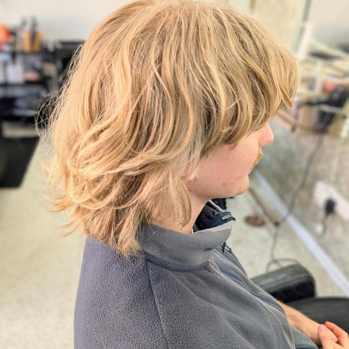 Blonde shoulder-length hair with layered textured waves in a side profile view.