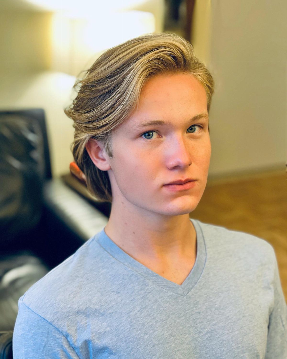 Young man with light brown hair styled in a clean side part.