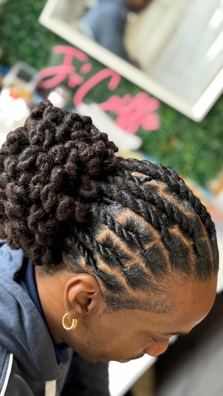 Man with long dark hair styled in twists and a large bun.