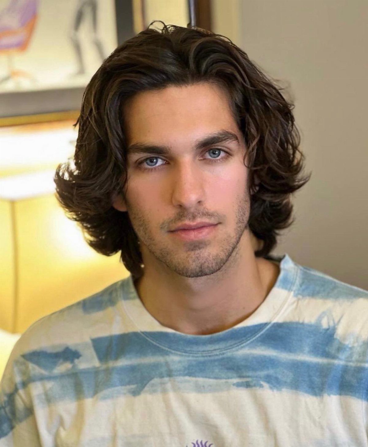 Man with wavy, shoulder-length brown hair and a relaxed, beachy hairstyle.