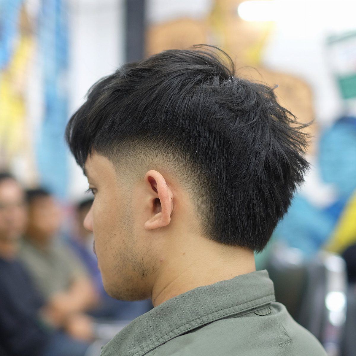 Man with a burst fade haircut, featuring long black hair on top and back.