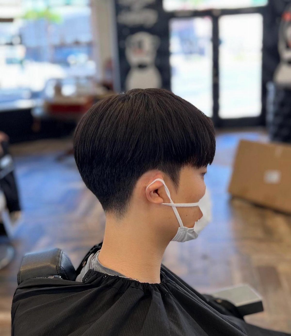 Man with a two-block haircut featuring long top hair and shaved sides.