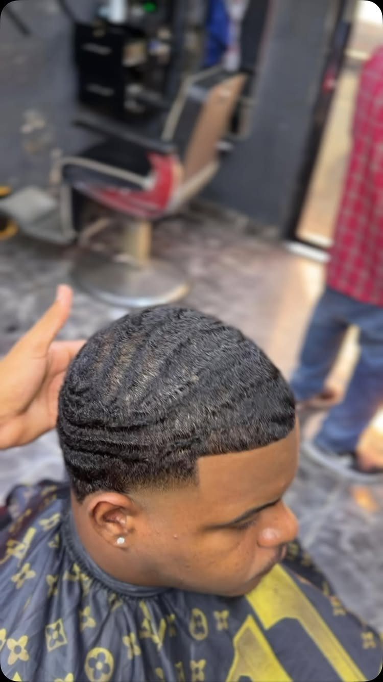 Man with 360 waves and a mid fade haircut in a barbershop.