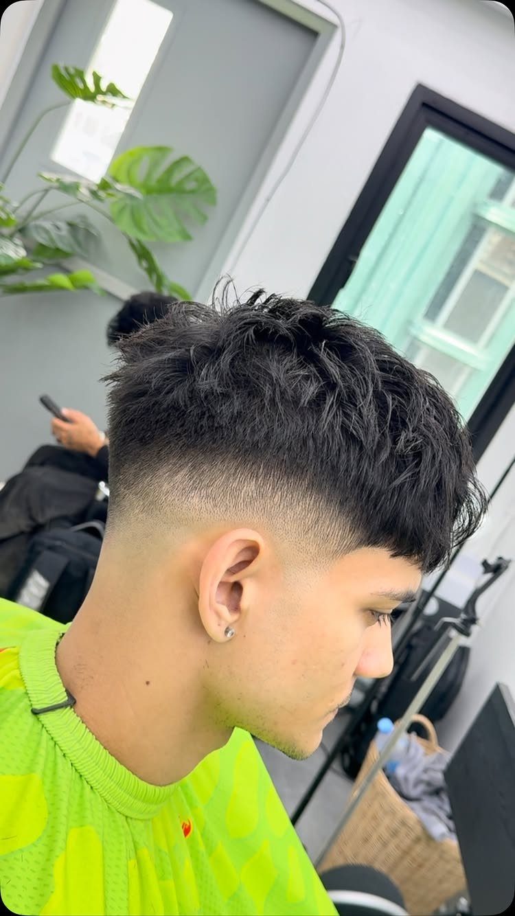 Young man with a textured crop haircut and mid skin fade side profile