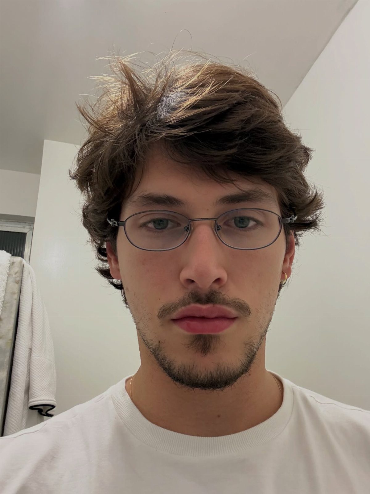 Young man with glasses featuring a trimmed mustache and a small hipster goatee.