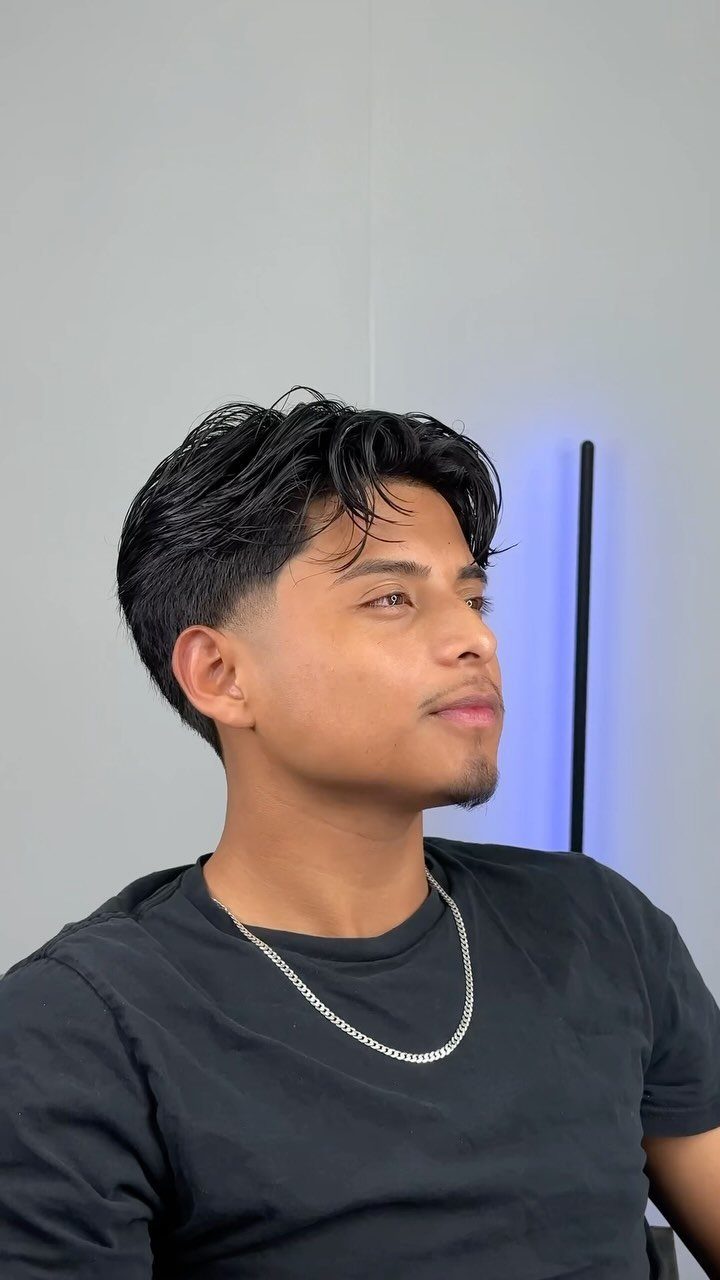 Young man with a straight, dark side-parted haircut and tapered sides.