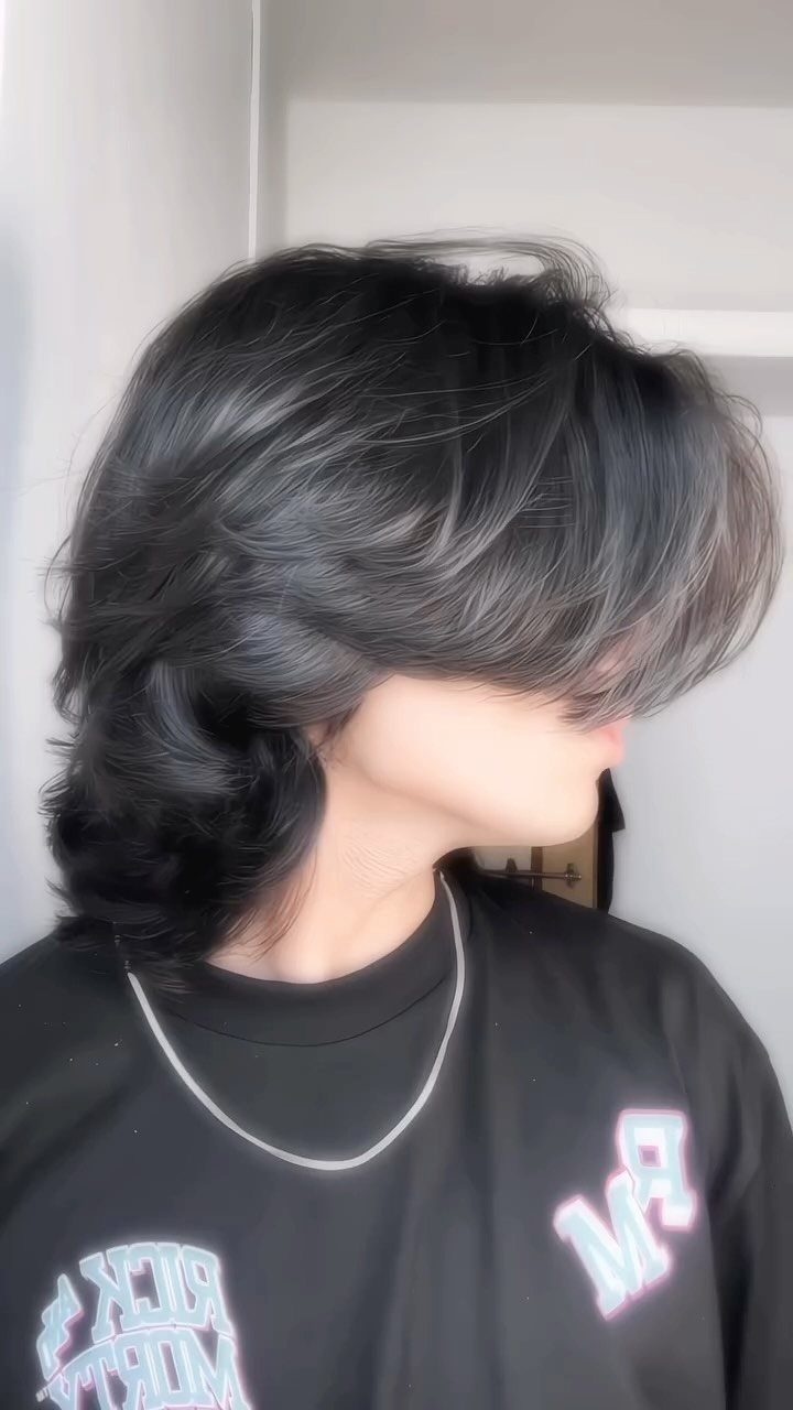 Person with a long black wolf cut hairstyle featuring voluminous layers and length.